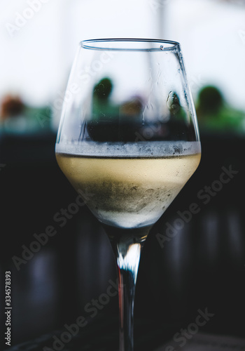 Wineglass with a white wine on a table.