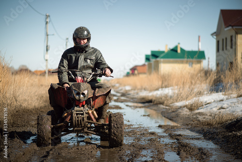 Foto Biker riding quad bike on dirty countryside road.