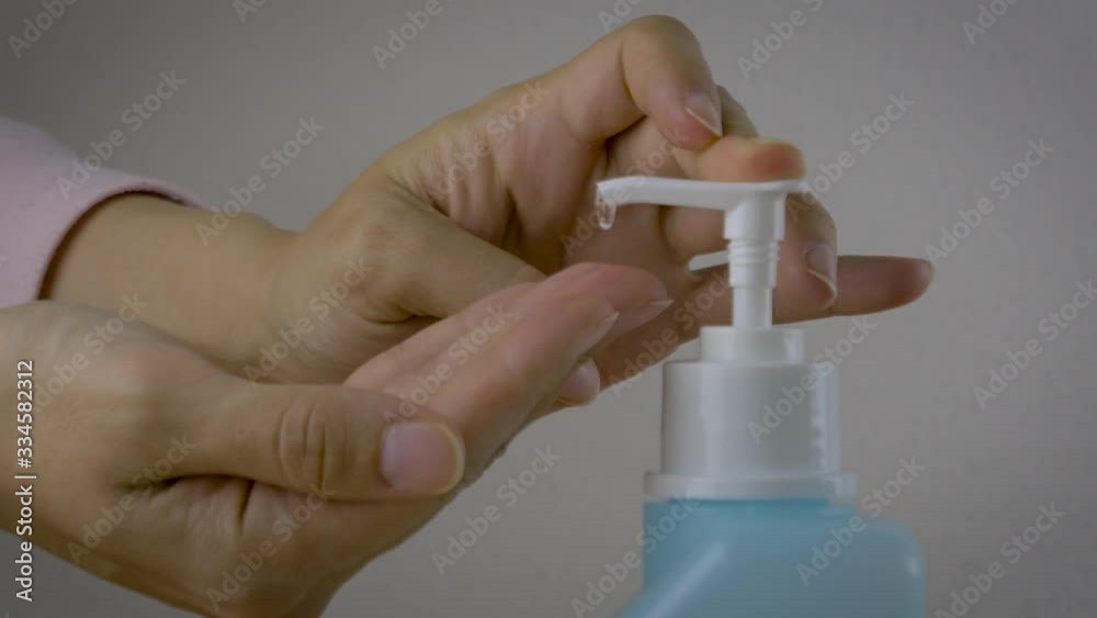 A woman is disinfecting hands rubbing with a sanitizer for corona virus prevention, hygiene to stop spreading coronavirus. Concept of early healthy hygiene learning and disease spreading prevention. A woman is disinfecting hands rubbing with a sanitizer for corona virus prevention, hygiene to stop spreading coronavirus. Concept of early healthy hygiene learning and disease spreading prevention.