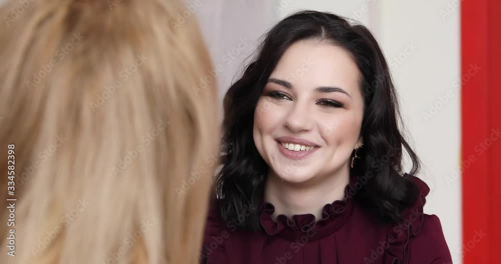 portrait of a girl who is talking with her friend and laughing portrait of a girl who is talking with her friend and laughing