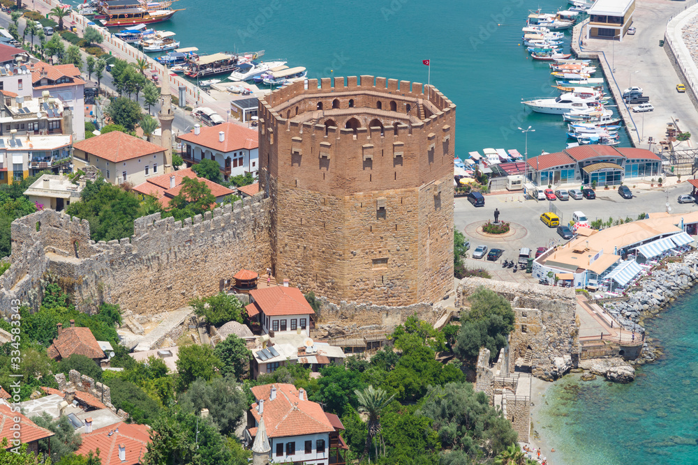 Alanya. Turkey. Red Tower (Kizil Kule) and the ruins of the fortress wall.