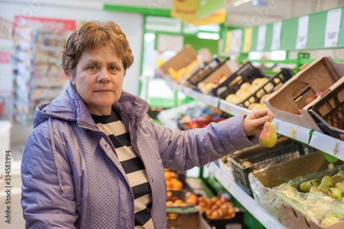 Russia, Ryazan - March 27, 2020: a female customer buys products in a supermarket and puts them in a shopping trolley.