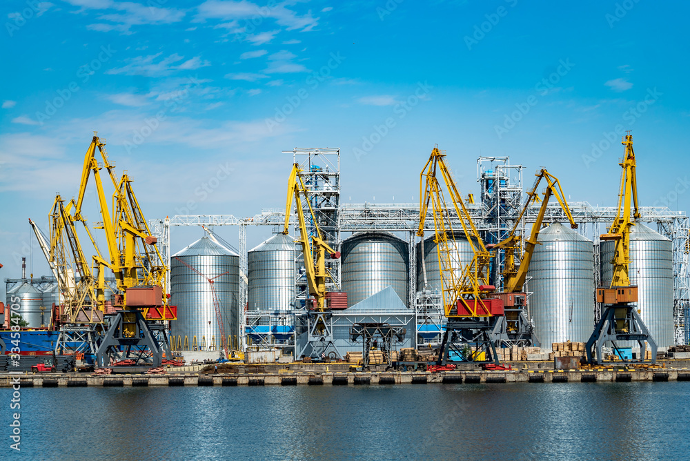 Panorama of the port cranes. Sea port with cranes and docks at blue sky background. Panorama of the port cranes. Sea port with cranes and docks at blue sky background.