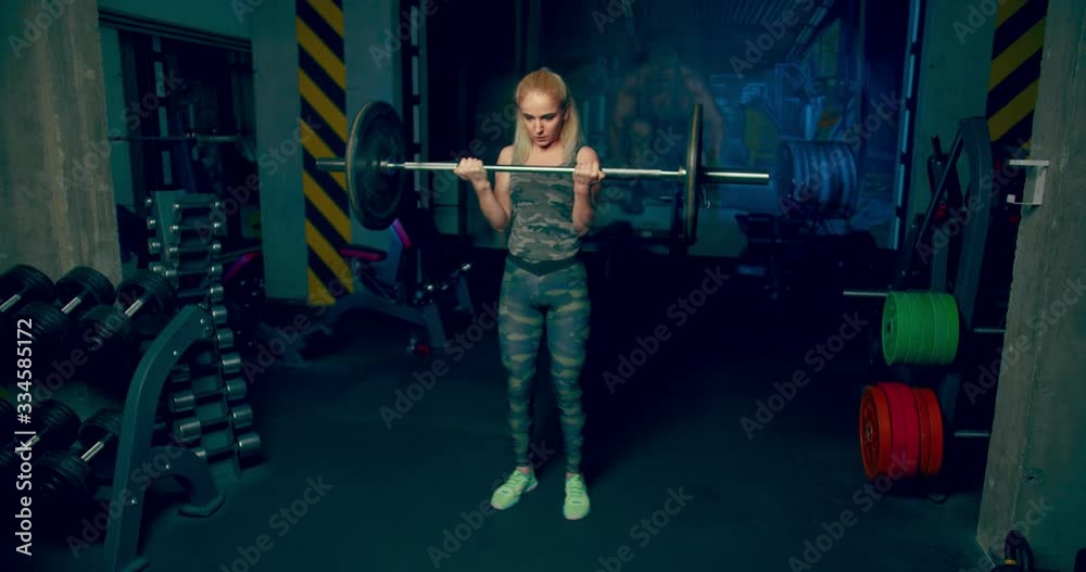 girl doing barbell exercise for biceps in sports gym front view girl doing barbell exercise for biceps in sports gym front view