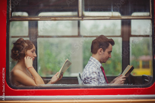 A guy and a girl ride a bus and read books