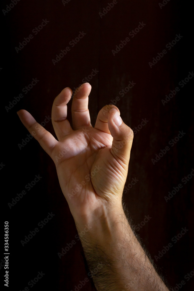 Man hand on black background. Gesture language with the hands. Non-verbal communication concept. Man hand on black background. Gesture language with the hands. Non-verbal communication concept.
