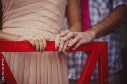 hands of people in love on the railing of a vintage tram
