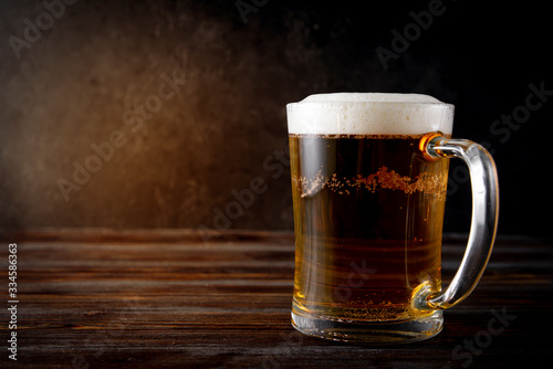  alcoholic drink , light beer, beer mug on a dark wooden background,