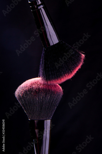 Colorful explosion on makeup brushes on a black background