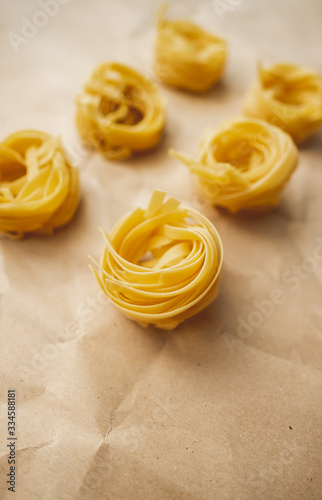 Italian wheat pasta tagliatelle on a craft paper. Top view