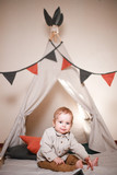 Cute little boy playing in a teepee