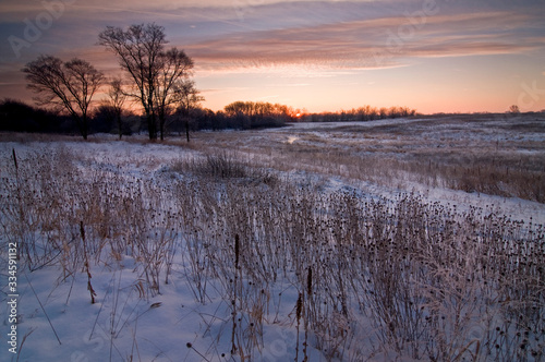 A winter sunrise over a tranquil, snow-covered Midwest prairie. © Mark Baldwin