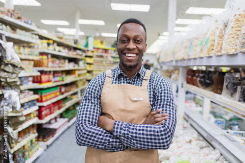 Portrait confident smiling male grocer working in supermarket photo