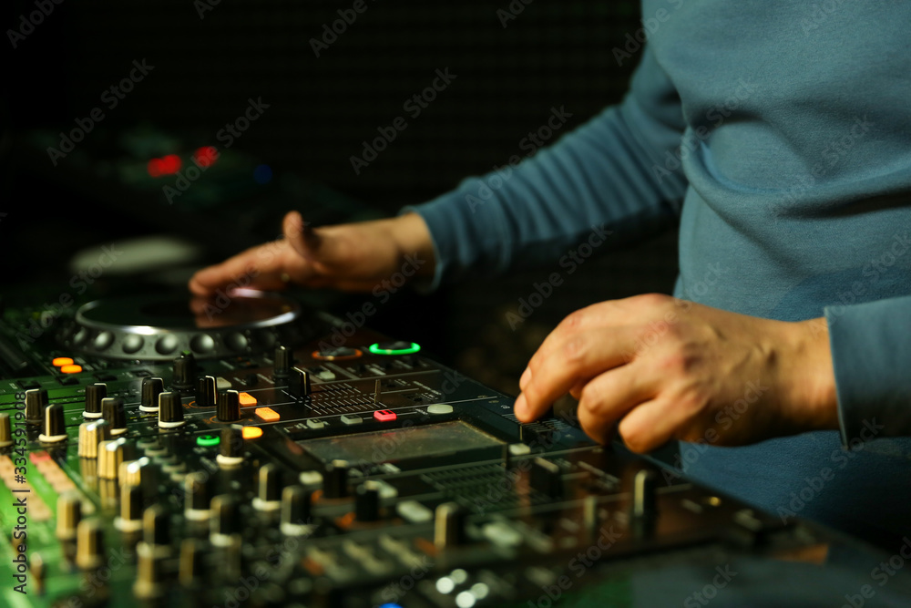 dj is mixing tracks at party in night club. disc jockey playing music on the modern turntable close up. dj is mixing tracks at party in night club. disc jockey playing music on the modern turntable close up.