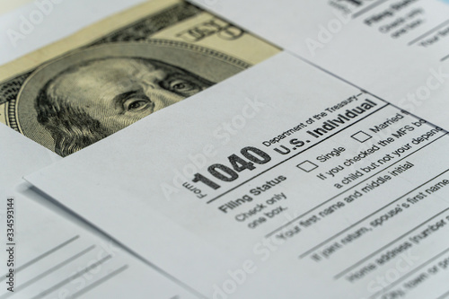 Tax form with pen and dollar banknote