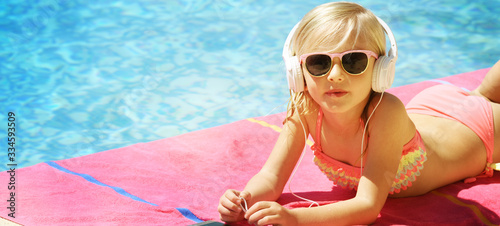 Photo Children blond girl in swimming pool. Summer vacations.
