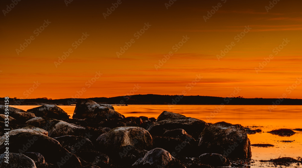 Złota godzina nad skalistym wybrzeżem podczas zachodu słońca w Parku Narodowym Ytre Hvaler w Norwegii - obrazy, fototapety, plakaty 