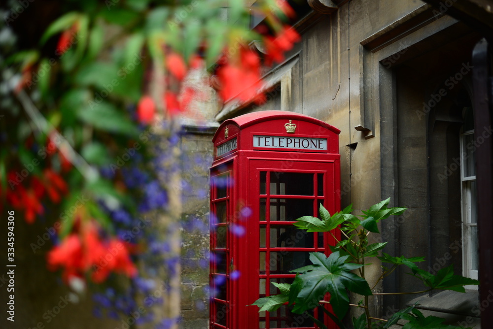 Obraz premium tradicional english phone booth with flowers around