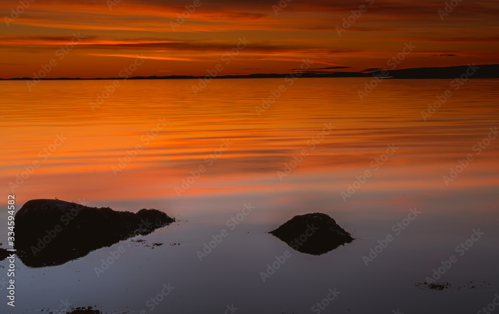Złota godzina nad skalistym wybrzeżem podczas zachodu słońca w Parku Narodowym Ytre Hvaler w Norwegii - obrazy, fototapety, plakaty 