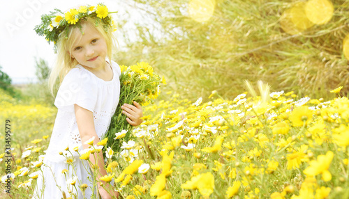 Children blond girl with daisy flowers. Summer vacation time. Country side.
