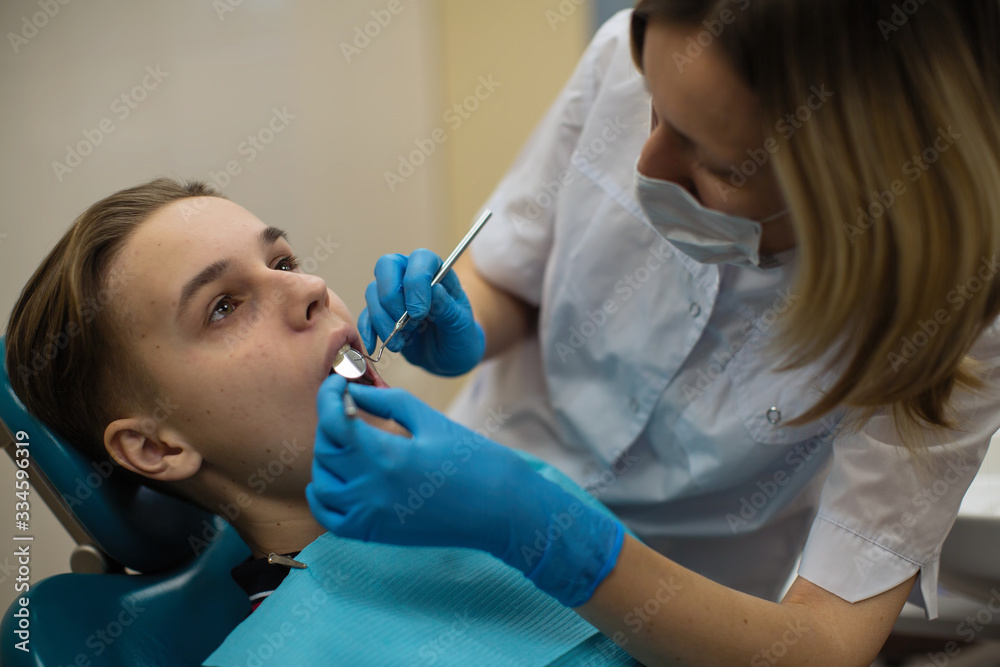 Dentist doing teeth checkup of guy in stomatology clinic. Dentist doing teeth checkup of guy in stomatology clinic.