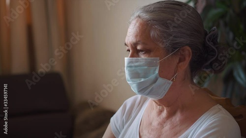 Working from home. Pandemic. Senior Woman do office job at home wearing protective mask