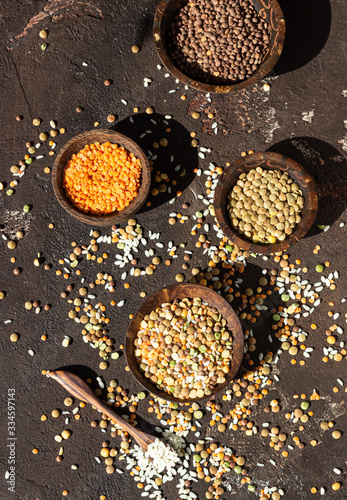 White rice and different types of lentil, dark brown concrete background. Agricultural product concept.