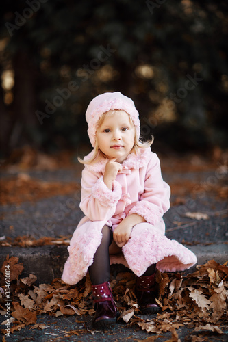 Fashionable little girl in a pink coat