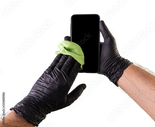 Hand cleaning a smartphone with black gloves. Preventing household cleaning against coronavirus photo