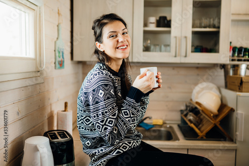 фотографія Woman in small kitchen drinking morning coffee