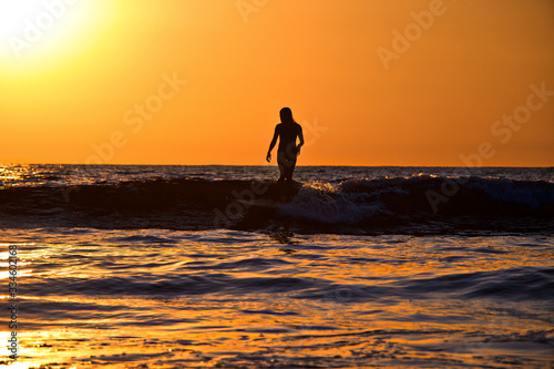 woman surfing at sunset