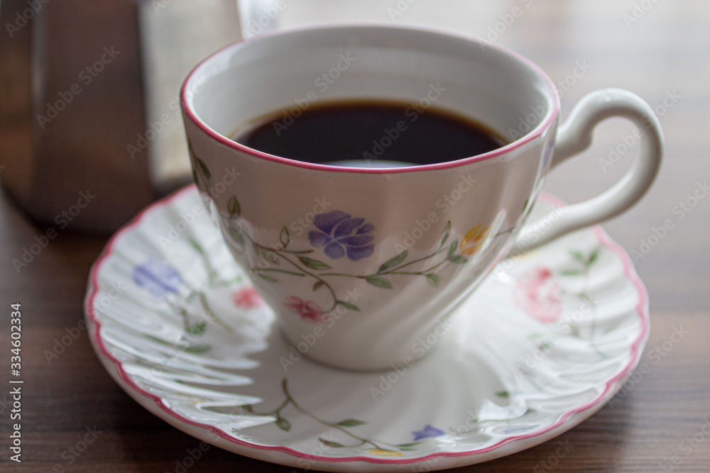 Coffee cup with a saucer and an italian coffee maker close up Coffee cup with a saucer and an italian coffee maker close up