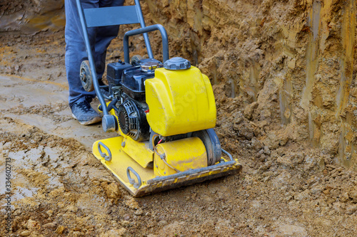 Vibratory plate compactor in construction rammer ground compaction foundation for construction of underground photo