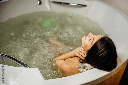 Woman relaxing at home in the hot tub bath ritual.Spa day moment in modern bathroom indoors jacuzzi tub.Leisure activity.Self care.Good personal hygiene routine.Skincare,spa,aromatherapy.Antistress
