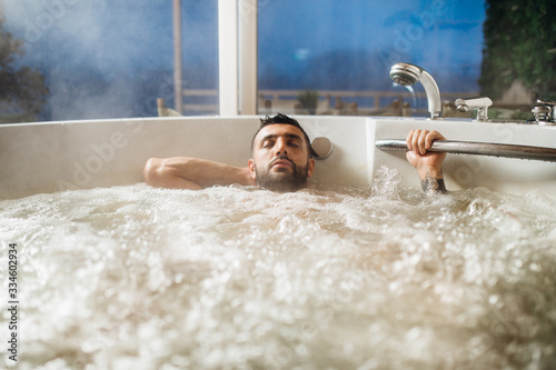 Фототапет Man relaxing at home in the hot tub bath ritual
