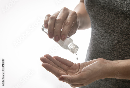 woman applying antibacterial gel to disinfect hand