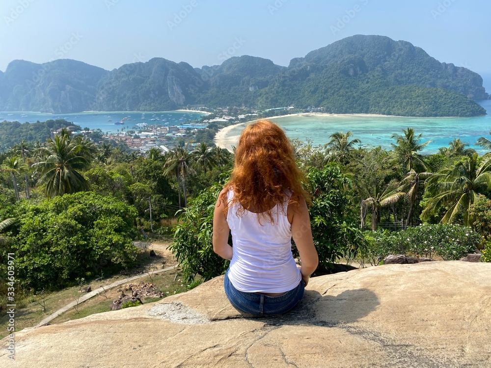 woman sitting on top of mountain with a view on Phi Phi island