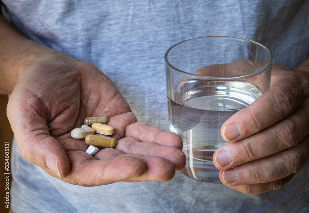male hands holding pills and grass of water male hands holding pills and grass of water