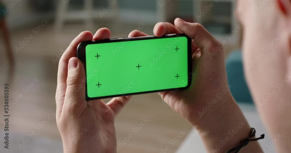 Man using a smart phone with mock up green screen, talking while having an online conference - online education, communications concept close up 4k video template