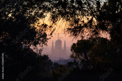 Sagrada Familia cathedral silhouettein the sunrise, framed by trees, Barcelona, Spain photo