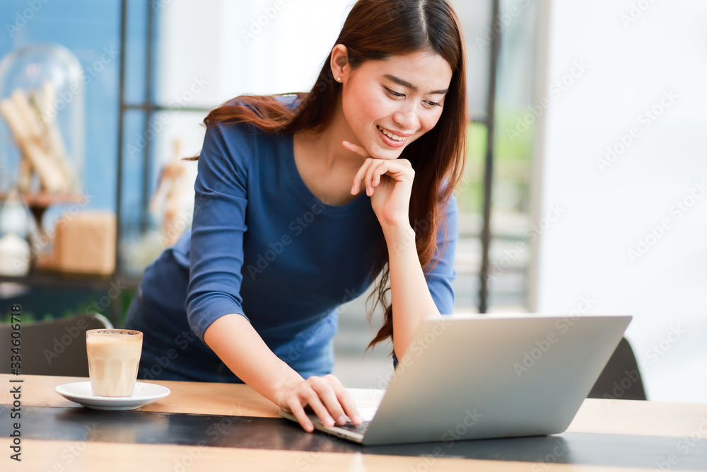 Asian woman using computer laptop and drink coffee work from home concept Asian woman using computer laptop and drink coffee work from home concept