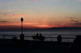Silhouette of two people sitting on bench during the sunset