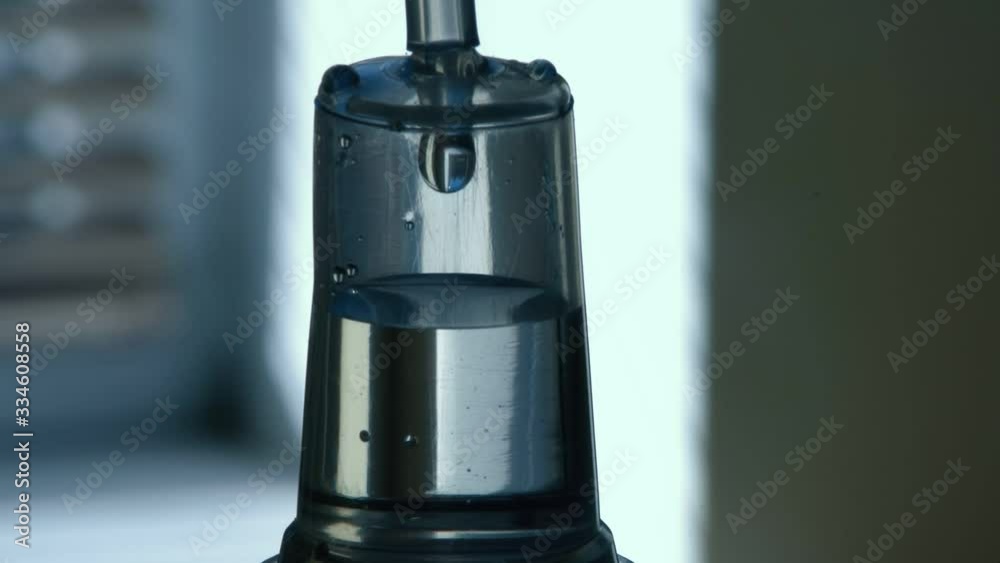 Transparent dropper with medical liquid dribbling down in an airy hospital ward Transparent dropper with medical liquid dribbling down in an airy hospital ward