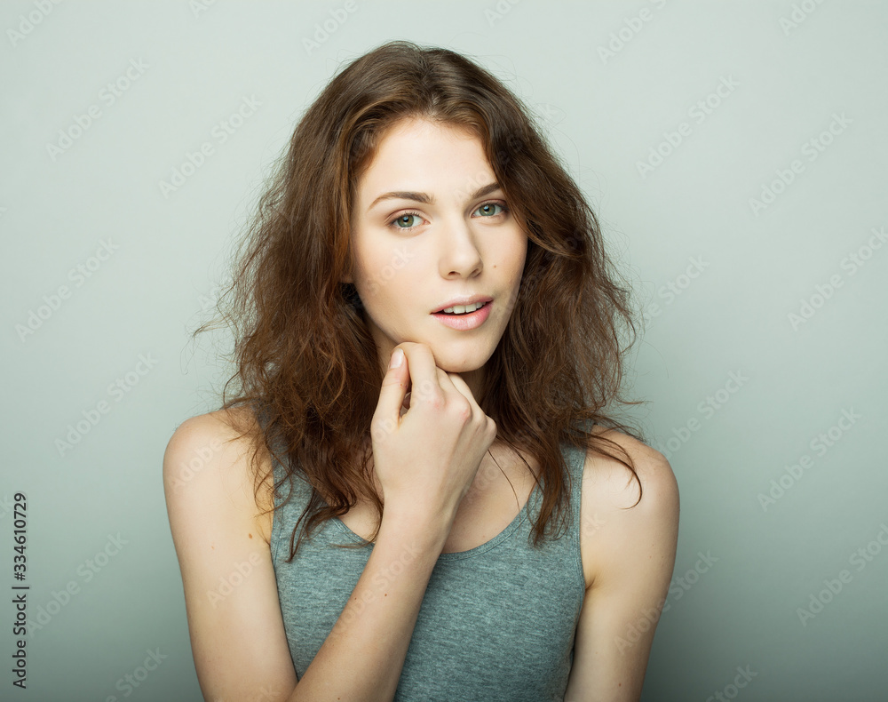 lifestyle and people concept: Young casual woman portrait. Clean face, curly hair.