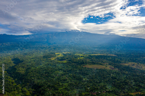 Beautiful view of Mount Kilimanjaro in Tanzania. Mighty volcano standing in the middle of jungle. photo