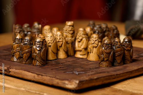 Wooden Viking chess hnefatafl on a wooden carved board made of dark wood, handmade