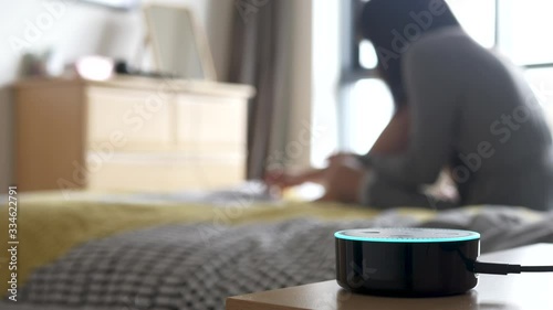 Millennial Woman Using Alexa Smart Home Assistant, Painting Nails in the Background