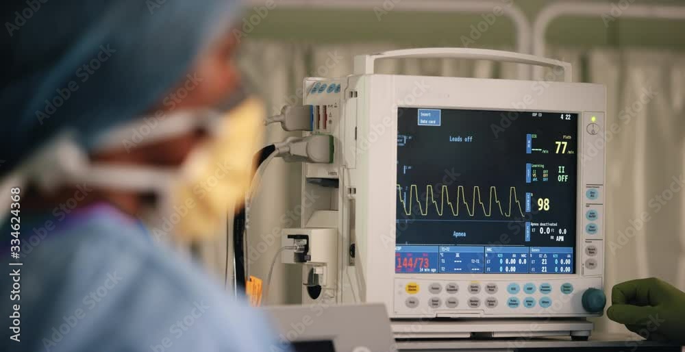 Surgeon Pressing Button on Heart Rate Monitor Surgeon Pressing Button on Heart Rate Monitor