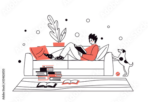 Man at home, lying on the sofa, reading books. Home library. The concept of reading paper literature. Young adult man having a rest with good book. Boy enjoying himself at home.