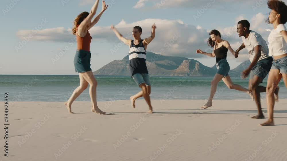 Group of multi-ethnic friends running and enjoying on the beach. Carefree young people having a great time together on a vacation. Group of multi-ethnic friends running and enjoying on the beach. Carefree young people having a great time together on a vacation.